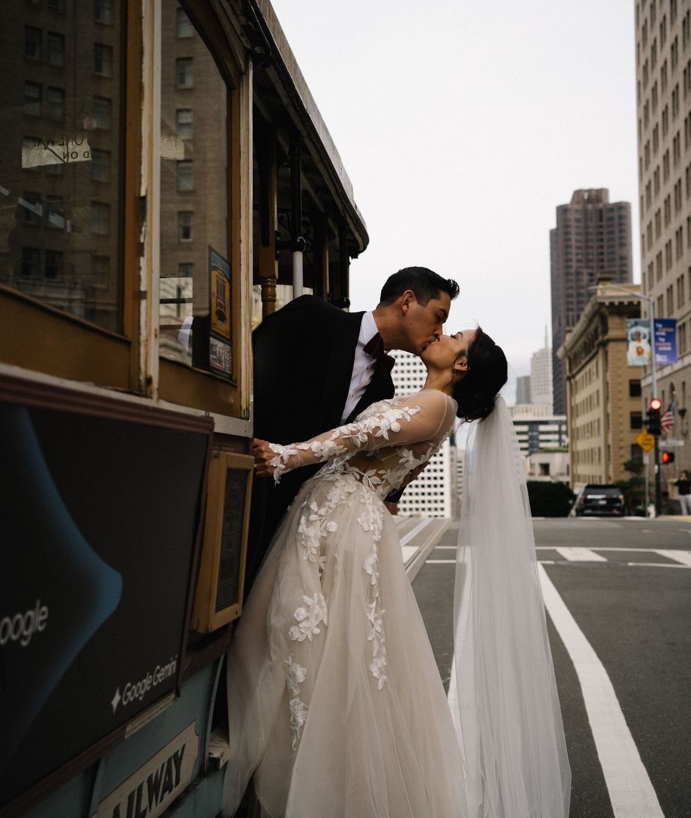 a brife and a groom kissing on a tram